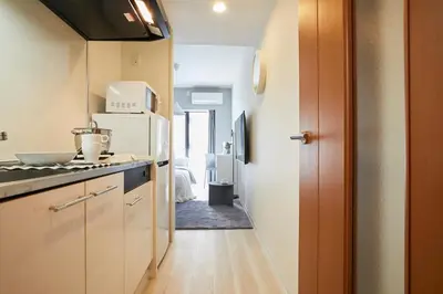 a small kitchen with a refrigerator and a hallway at P OIN T - Shinjuku Kabukicho Designer's Apartment II in Tokyo