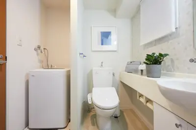 a white bathroom with a toilet and a sink at P OIN T - Shinjuku Kabukicho Designer's Apartment II in Tokyo