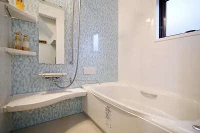 a bathroom with a tub and a sink and a mirror at MUMU HOUSE in Tokyo