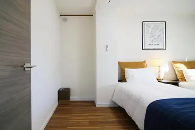 a bedroom with a bed with a blue blanket at MUMU HOUSE in Tokyo