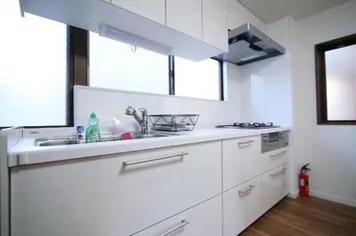 a white kitchen with a sink and a stove at MUMU HOUSE in Tokyo