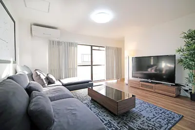 a living room with a couch and a flat screen tv at MUMU HOUSE in Tokyo