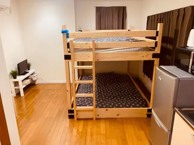 a bunk bed in a small room with a kitchen at Tokyo Stay Nakano in Tokyo