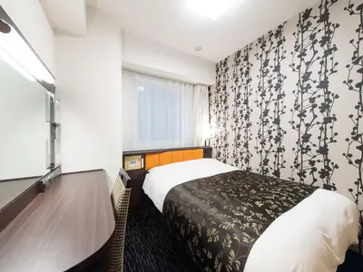 a hotel room with a bed and a window at APA Hotel Ueno Hirokoji in Tokyo