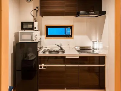 a kitchen with a sink and a microwave at YADOYA Karasumain in Tokyo