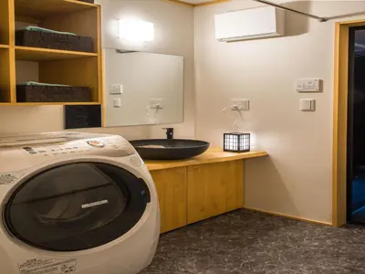 a bathroom with a sink and a tv on a counter at YADOYA Karasumain in Tokyo