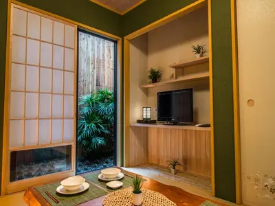 a room with a table and a tv and a window at YADOYA Karasumain in Tokyo
