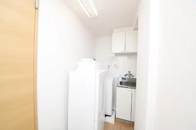 a small kitchen with white cabinets and a sink at ACT Residence No.1 in Tokyo
