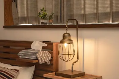 a lamp on a night stand next to a bed at Jomira & Jony House in Tokyo