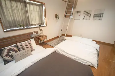 a room with a bed and a ladder and a window at Jomira & Jony House in Tokyo