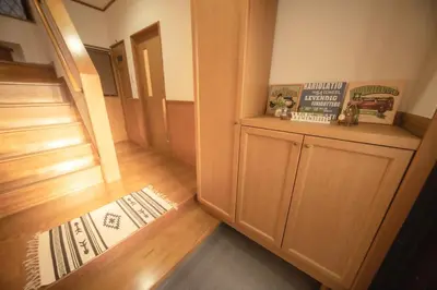 a room with a hallway with wooden floors and a door at Jomira & Jony House in Tokyo
