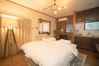 a bedroom with a large bed with white sheets at Jomira & Jony House in Tokyo