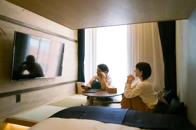two women sitting at a table in a hotel room at Sakura Cross Hotel Shinjuku East Annex in Tokyo