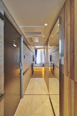 a hallway with a door leading to a waiting room at Sakura Cross Hotel Shinjuku East Annex in Tokyo