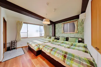 a bedroom with two beds and a window at Terrace Terano#201 in Tokyo