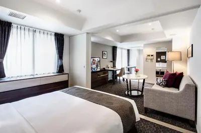 a hotel room with a bed and a chair and a desk at Somerset Ginza East Tokyo in Tokyo