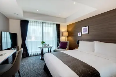 a hotel room with a large bed and a table at Somerset Ginza East Tokyo in Tokyo