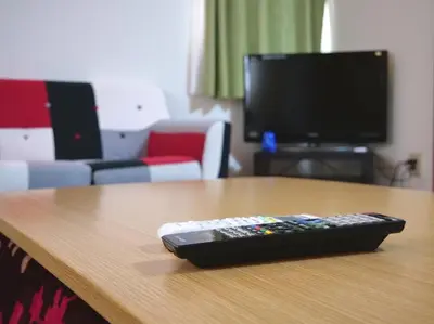 a remote control sitting on top of a wooden table at Koto-ku - House / Vacation STAY 76385 in Tokyo