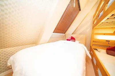 a small bedroom with a bed and a window at kaguya asakusa Women only guest house in Tokyo