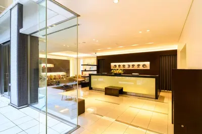 a living room with a glass wall at Richmond Hotel Tokyo Shiba in Tokyo