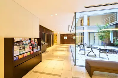 a lobby of a building with a table and chairs at Richmond Hotel Tokyo Shiba in Tokyo