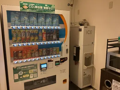 a vending machine with a drink dispenser next to a refrigerator at Richmond Hotel Tokyo Shiba in Tokyo
