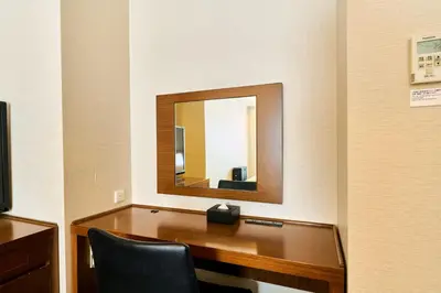 a desk with a mirror in a room at Richmond Hotel Tokyo Shiba in Tokyo