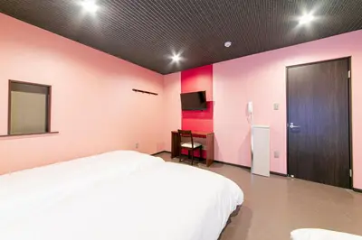 a bedroom with a white bed and pink walls at Wa no Kaede in Tokyo