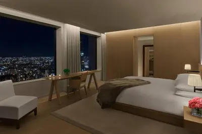 a bedroom with a bed and a table and a window at The Tokyo EDITION, Toranomon in Tokyo
