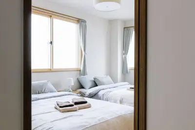 two beds in a room with a mirror at Akiba Residence in Tokyo