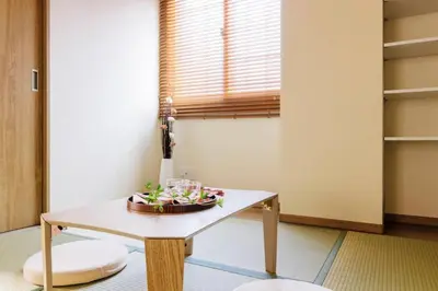 a room with a table with a bowl of flowers on it at Akiba Residence in Tokyo