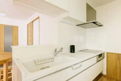 a white kitchen with a sink and a microwave at Akiba Residence in Tokyo