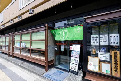 a store with a green banner on the side of a building at Re-Rent Residence \u62bc\u4e0a in Tokyo