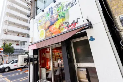 a restaurant with a sign on the side of a building at Re-Rent Residence \u62bc\u4e0a in Tokyo