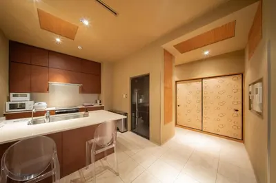 a kitchen with a sink and a counter with chairs at Azabu Modern House The Tokyo Tower can be seen from the villa 500m2 in Tokyo