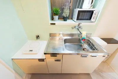 a small kitchen with a sink and a microwave at Shinjuku-ku - House / Vacation STAY 6644 in Tokyo