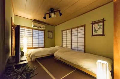 two beds in a room with green walls and windows at Shinjuku-ku - House / Vacation STAY 6644 in Tokyo