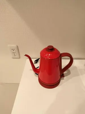 a red tea kettle sitting on top of a counter at Tachibana in Tokyo