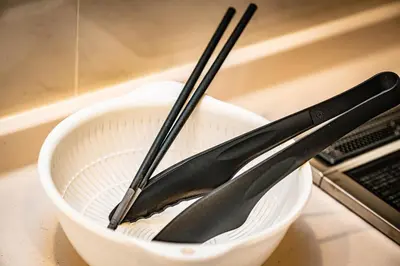 a pair of tongs sitting in a white bowl at Tachibana in Tokyo