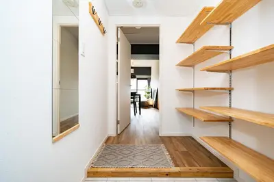 a hallway with wooden stairs and white walls at Eims stay Oomori304 in Tokyo