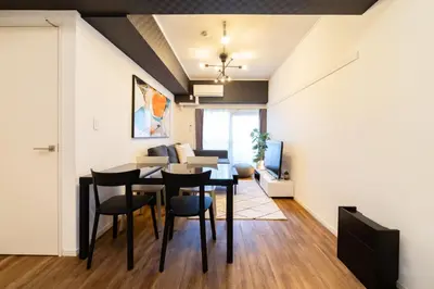 a dining room and living room with a table and chairs at Eims stay Oomori304 in Tokyo