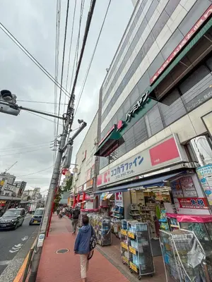 a woman walking down a sidewalk in front of a store at Eims stay Oomori304 in Tokyo