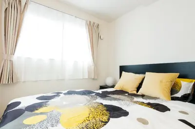 a bedroom with a large bed with a large window at Crescent Moon Nakanoshimbashi in Tokyo