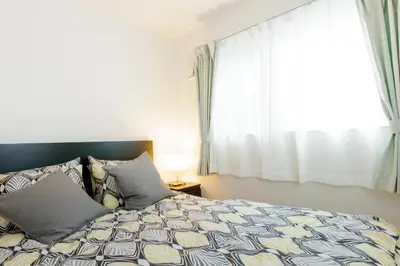 a bedroom with a bed and a window at Crescent Moon Nakanoshimbashi in Tokyo