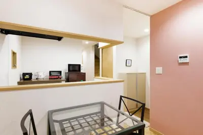 a dining room with a glass table and chairs at Crescent Moon Nakanoshimbashi in Tokyo