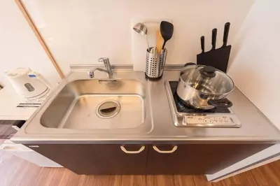 a kitchen counter with a sink and a stove at TORA HOTEL Tokyo Skytree \u5bc5\u30db\u30c6\u30eb \u30b9\u30ab\u30a4\u30c4\u30ea\u30fcC in Tokyo