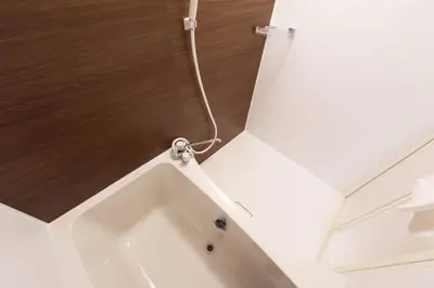 a bath tub with a hose hanging from a ceiling at TORA HOTEL Tokyo Skytree \u5bc5\u30db\u30c6\u30eb \u30b9\u30ab\u30a4\u30c4\u30ea\u30fcC in Tokyo