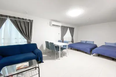 a living room with blue couches and a table at FL Residence Takadanobaba in Tokyo