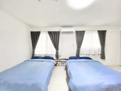 two beds sitting in a room with windows at FL Residence Takadanobaba in Tokyo