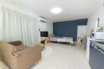 a small living room with a couch and a kitchen at FL Residence Takadanobaba in Tokyo